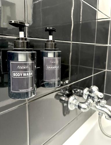 two bottles of soap sitting on a shelf in a bathroom at Casa Thamay in Brindisi