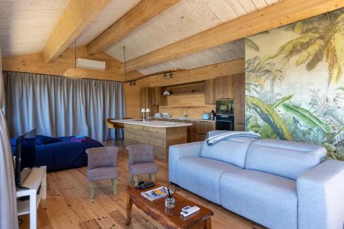 ein Wohnzimmer mit einem Sofa und einer Küche in der Unterkunft Le Lodge de la Presqu’île de Giens in Hyères