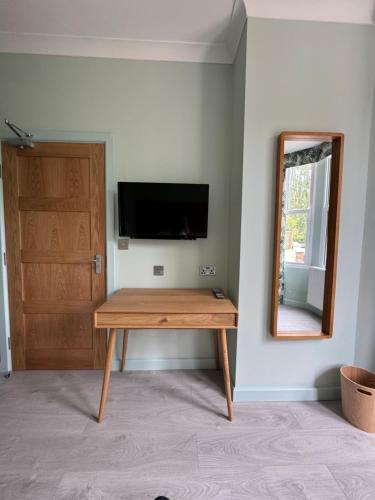 a room with a wooden table and a mirror at Hamilton Court Hotel Hoole in Chester