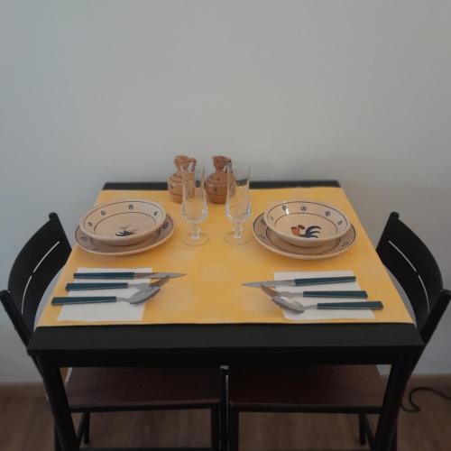 ein Tisch mit zwei Tellern und Gläsern darauf in der Unterkunft Casa Alba in Lecce