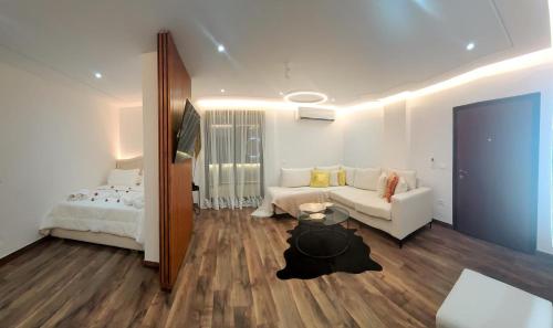 a living room with a white couch and a bed at My Sky Përmet in Përmet