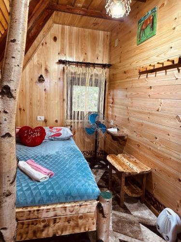 una camera con un letto in una baita di tronchi di Durmitorske kolibe a Žabljak