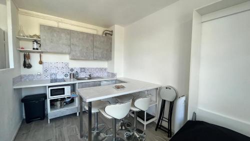 - une petite cuisine avec une table et des tabourets dans l'établissement Studio marseille calanques, à Marseille