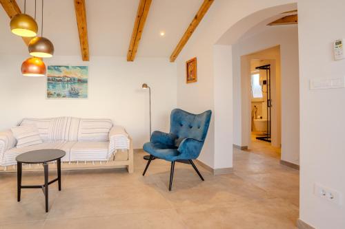 a living room with a blue chair and a couch at Apartment Hrabrić in Njivice