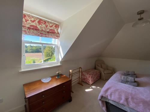 a attic bedroom with a bed and a window at Private detached cottage sleeps 4 in Crieff
