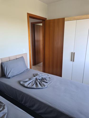 a bedroom with a bed with a towel on it at Ap 03 edificio Sao Paulo I in Ponta Grossa