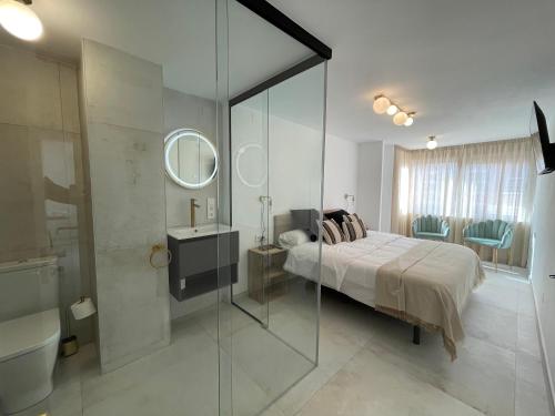 a bedroom with a bed and a sink and a mirror at Boutique Apartment Torrevieja Centro in Torrevieja