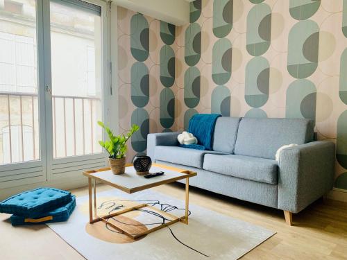 a living room with a couch and a table at Le Cocon central - Wifi - Transports et Commerces in Angoulême
