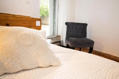 a bed with a pillow and a chair in a room at Le Pailler Chambres D'hôtes Restaurant Gîte piscine & spa in Verrières