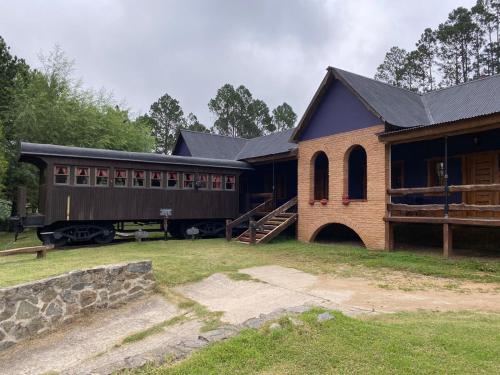 a barn with a train car parked in front of it at Suenos del Bosque ApartHotel in Atos Pampa