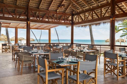 a restaurant on the beach with tables and chairs at Sunscape Coco Punta Cana - All Inclusive in Punta Cana