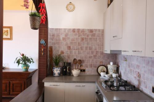 a kitchen with white cabinets and a brick wall at Domus Alba in Praiano