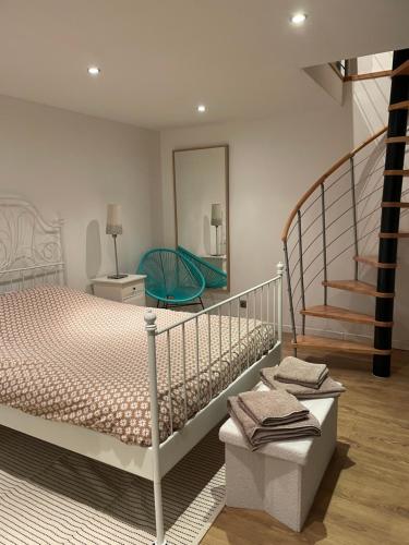 - une chambre avec un lit, un escalier et un miroir dans l'établissement Charmant gîte rural en Bretagne, à Rouillac