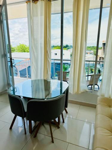 a glass table and chairs in a room with windows at TORRES DEL MESÓN LUXURY APARTA HOTEL Doradal in Doradal