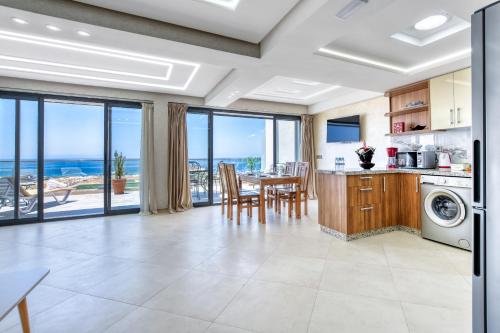a kitchen with a table and a dining room with views of the ocean at Baya house Tamraght in Tamraght Ouzdar