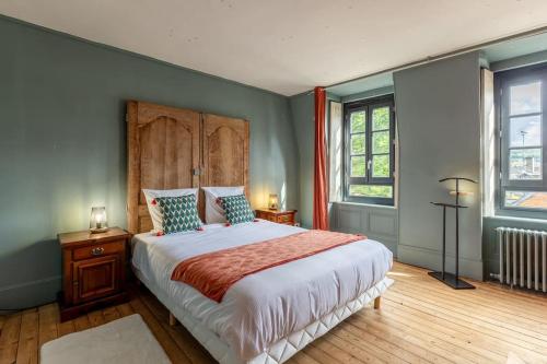 une chambre avec un grand lit et deux fenêtres dans l'établissement La Maison des Carmes - Patio couvert - Hypercentre, à Pont-Audemer