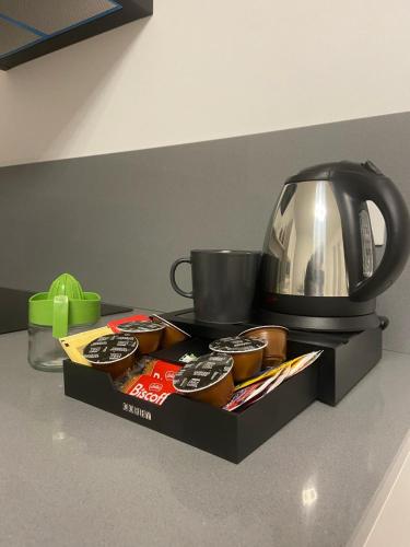 a tray of cupcakes and a tea kettle on a counter at LA ROSA DEL SILE in Quarto dʼAltino