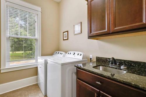 a kitchen with a washer and a sink and a window at Ocean View-3 Bdrm Plus Mother-In-Law Suite - E-bikes in Gulfport