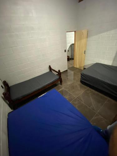 a room with two beds and a hallway with a door at Espaço Mattigor in Caçapava
