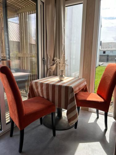 une table avec deux chaises et une table avec une nappe à rayures dans l'établissement Green Lodge, à Perros-Guirec