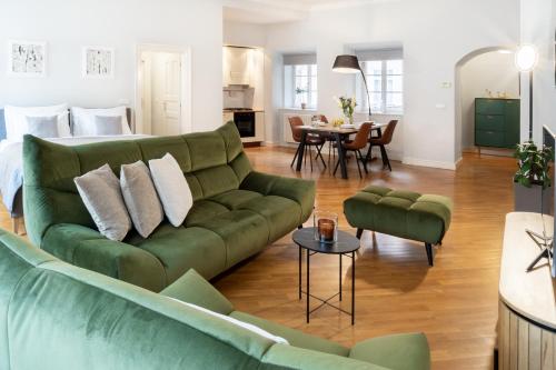 sala de estar con sofá verde y comedor en Prague Center Apartments, en Praga