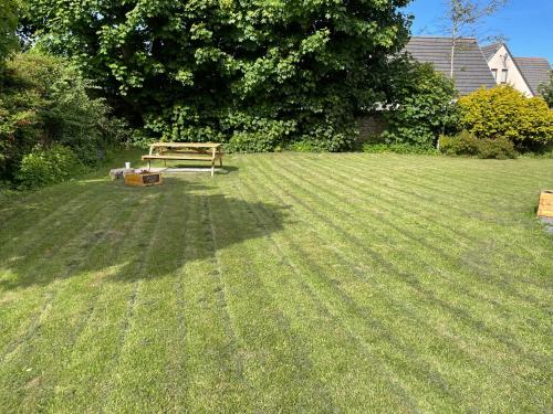 a bench sitting in the middle of a grassy yard at The Old Manse B&B in Thurso