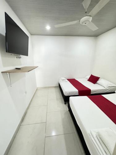 Cette chambre comprend 2 lits et une télévision à écran plat. dans l'établissement TORRES DEL MESÓN LUXURY APARTA HOTEL Doradal, à Doradal