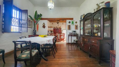 a dining room with a table and chairs and a kitchen at Casa Carmelita Hotel Boutique Pitalito in Pitalito