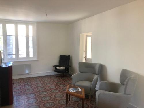 een wachtkamer met twee stoelen en een tafel bij Ibis Rouge in Villars-les-Dombes