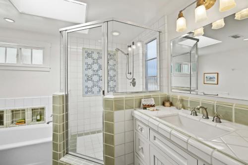 a white bathroom with a shower and a sink at Sand Side Bliss in Oxnard