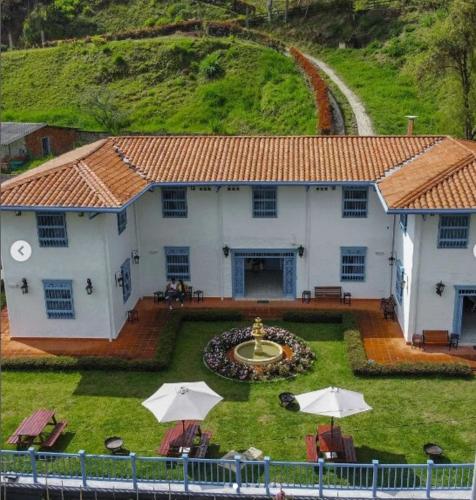 a large white building with a yard with umbrellas at Hotel Concepción Antioquia in Concepción