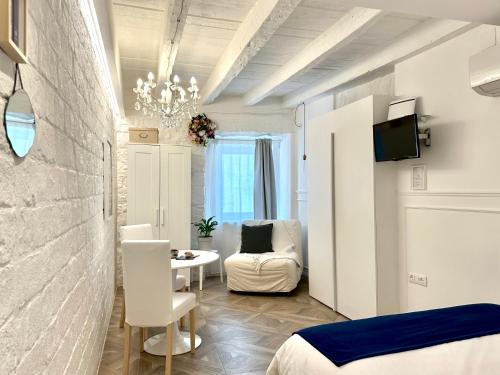 ein Schlafzimmer mit einem Bett, einem Tisch und einem Stuhl in der Unterkunft L ESSENZIALE a Trieste in Triest