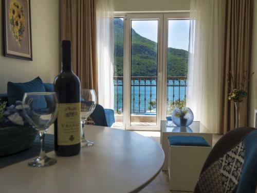 una bottiglia di vino seduta su un tavolo con due bicchieri da vino di Villas Promis a Čanj