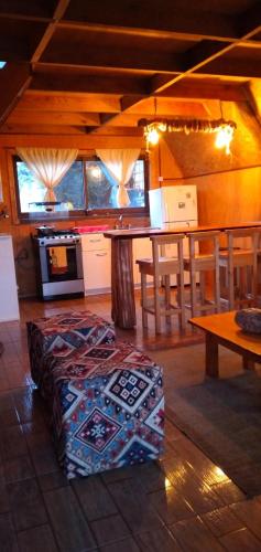 a room with a table and a table and a bench at CABAÑA PARCELA VISTA HERMOSA in Puerto Aisén