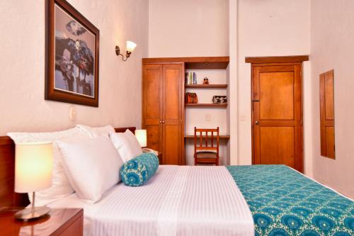 a bedroom with a bed and a table with a lamp at La Campana Hotel Boutique in Medellín