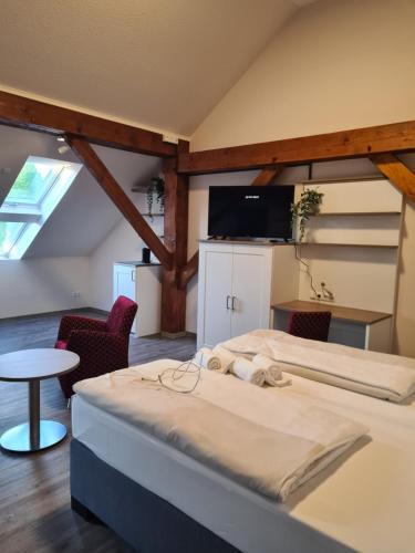 a bedroom with a bed and a table and chairs at Gasthuus Ulenhoff in Westoverledingen