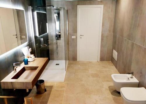 ein Bad mit einem Waschbecken, einer Dusche und einem WC in der Unterkunft Palazzo Scianni in Monopoli