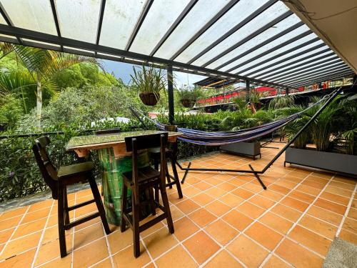 a patio with a hammock and a table and chairs at Tierra Maravilla in Salento