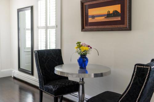 a table with a vase of flowers on top of it at The Platinum Pebble Boutique Inn - Adults Only Property in Harwich Port