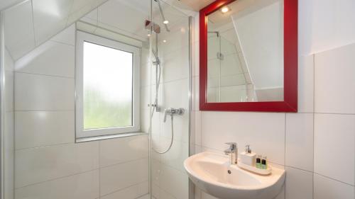 ein weißes Badezimmer mit Waschbecken und Fenster in der Unterkunft ERSTAY - moderne Zimmer in Dorsten