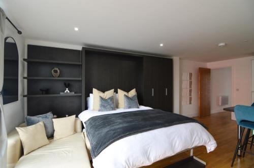 a bedroom with a large bed and a couch at Cosy, Centrally Located Studio With Gated Parking! in Loughborough