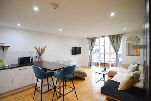 a kitchen and living room with a table and chairs at Cosy, Centrally Located Studio With Gated Parking! in Loughborough