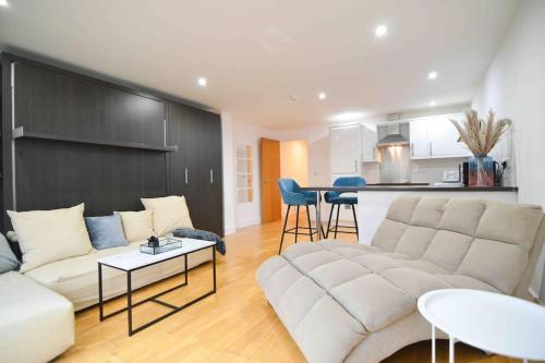 a living room with a couch and a table at Cosy, Centrally Located Studio With Gated Parking! in Loughborough