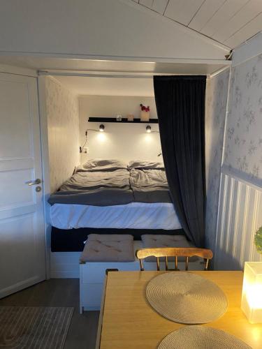 um pequeno quarto com uma cama e uma mesa em Stuga vättervy em Gränna