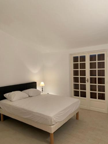 un lit blanc dans une chambre blanche avec une fenêtre dans l'établissement Maison DE VACANCES VUE MER PROCHE PLAGE AJACCIO SANGUINAIRES REF 1070, à Ajaccio