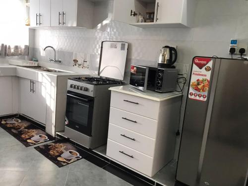 a kitchen with a stove and a refrigerator at JnB 2Bedroom Nakuru Naka Estate in Nakuru