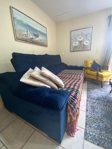 a blue couch with pillows on it in a room at Rancho Caiçara in São Francisco do Sul