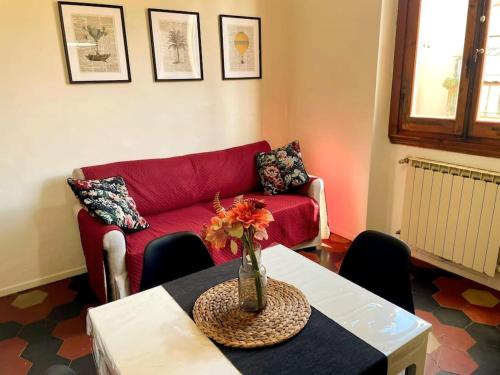 a living room with a red couch and a table at La nicchia dei sogni in Montevarchi