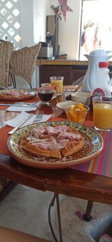 a table with a plate with a pizza on it at Amaranto Bed and Breakfast in Cozumel