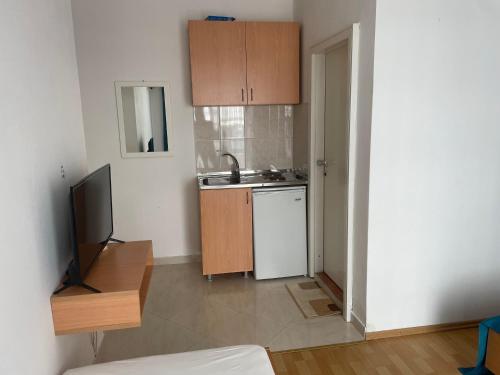 cocina con fregadero y TV en una habitación en Molla Apartments, en Ulcinj